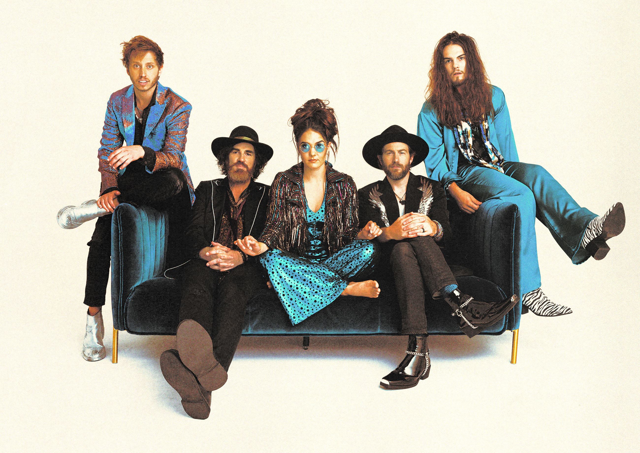 We The Kingdom band members sitting on couch